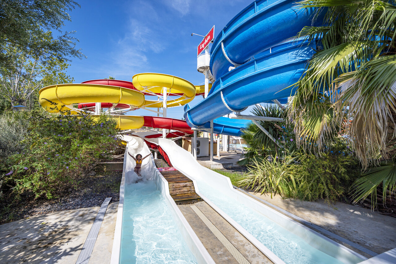 Toboggans aquatiques multicolores, enfant s'amusant au camping CAPFUN Fleurs d'Agde � AGDE (34).