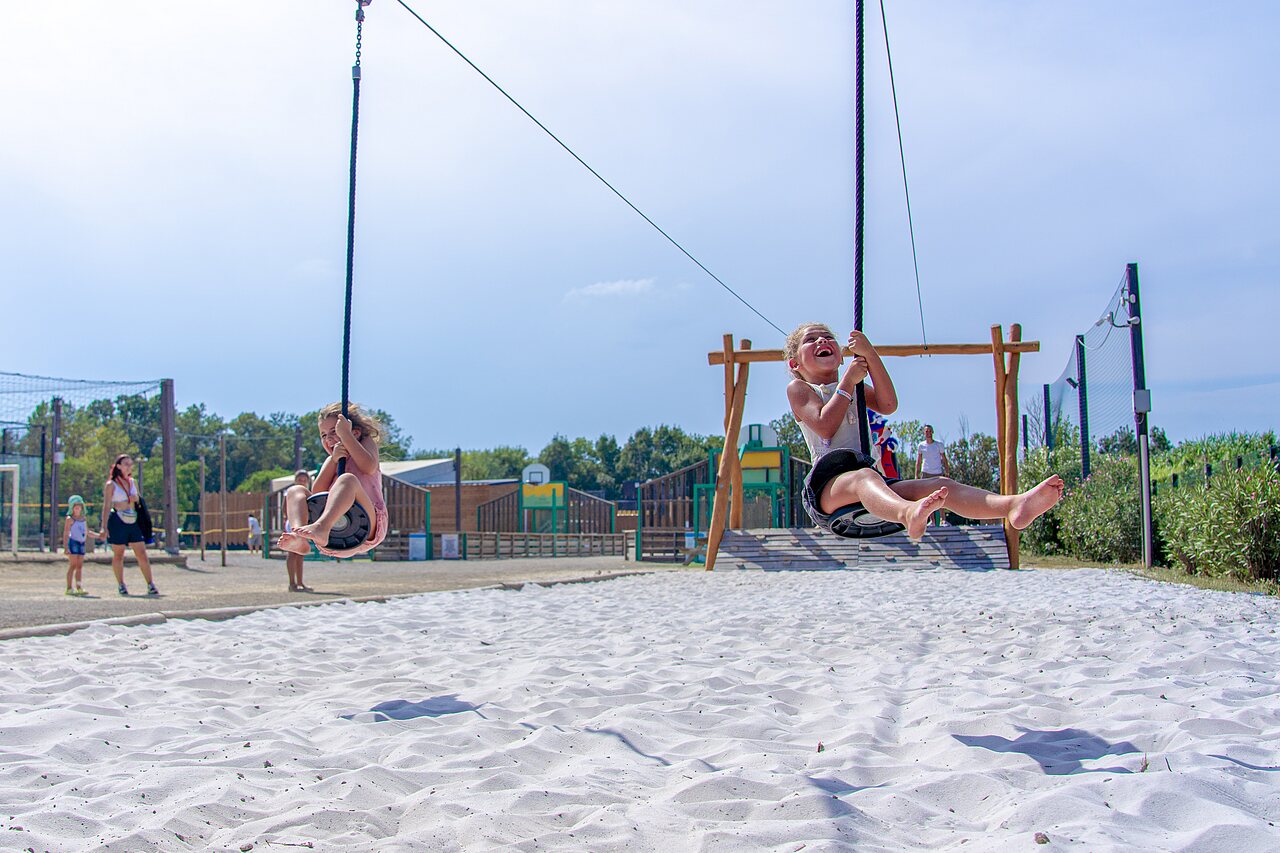 Enfants joyeux sur tyroliennes au-dessus du sable au camping CAPFUN Fleurs d'Agde � AGDE (34).