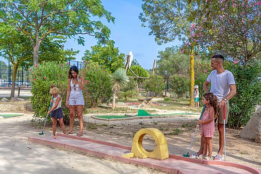 Famille jouant au mini-golf sur un parcours ext�rieur au camping CAPFUN Fleurs d'Agde � AGDE (34).