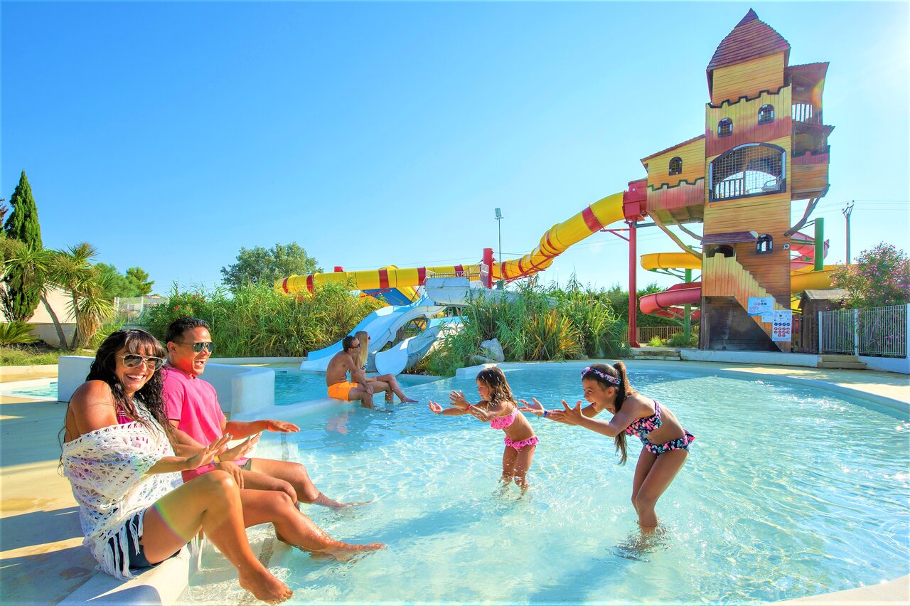 Piscine avec toboggans aquatiques, structure ch�teau et famille au camping CAPFUN Fleur de Camargue � Saint-Laurent-d Aigouze (30).