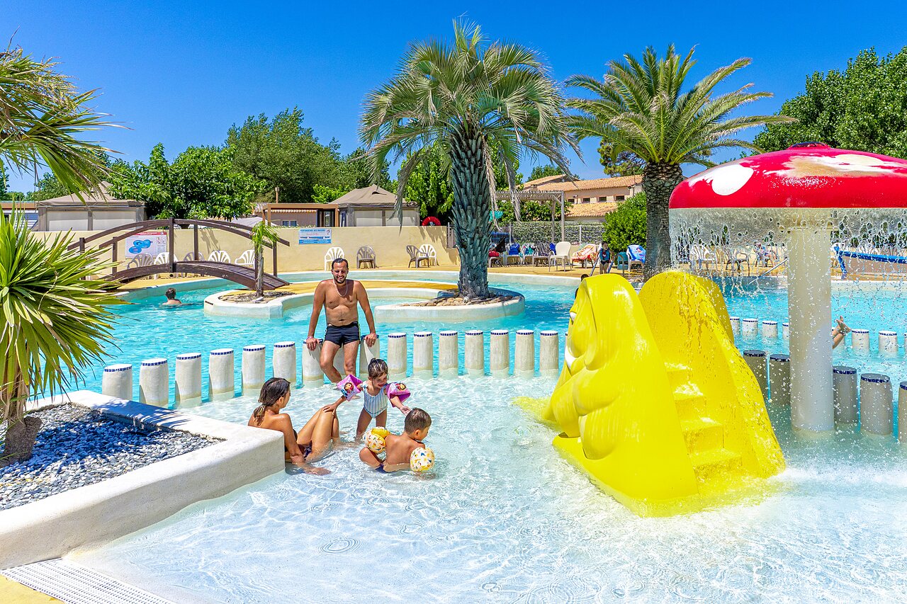 Piscine ext�rieure, toboggan jaune et jeux au camping CAPFUN Flots Bleus � VIAS PLAGE (34).