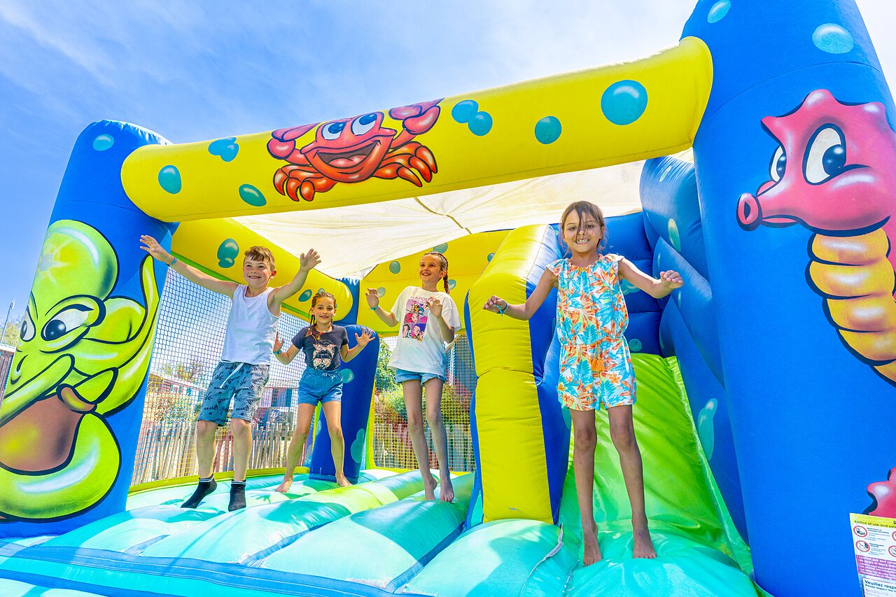 Enfants s'amusant sur ch�teau gonflable au camping CAPFUN Flots Bleus � VIAS PLAGE (34).