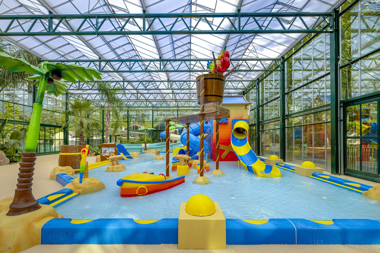 Aire de jeux aquatique couverte avec toboggans et seau g�ant au camping CLICOCHIC La For�t d'Azal�e � Saint-Ch�ron (91).