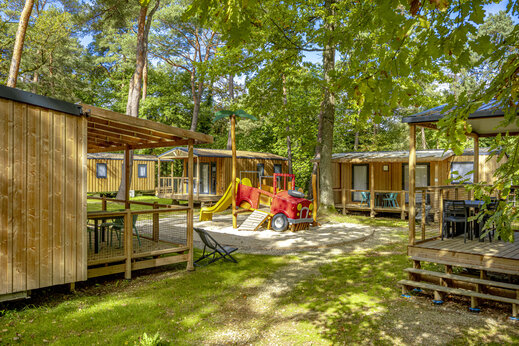 Mobil-homes en bois et aire de jeux au camping CLICOCHIC La For�t d'Azal�e.