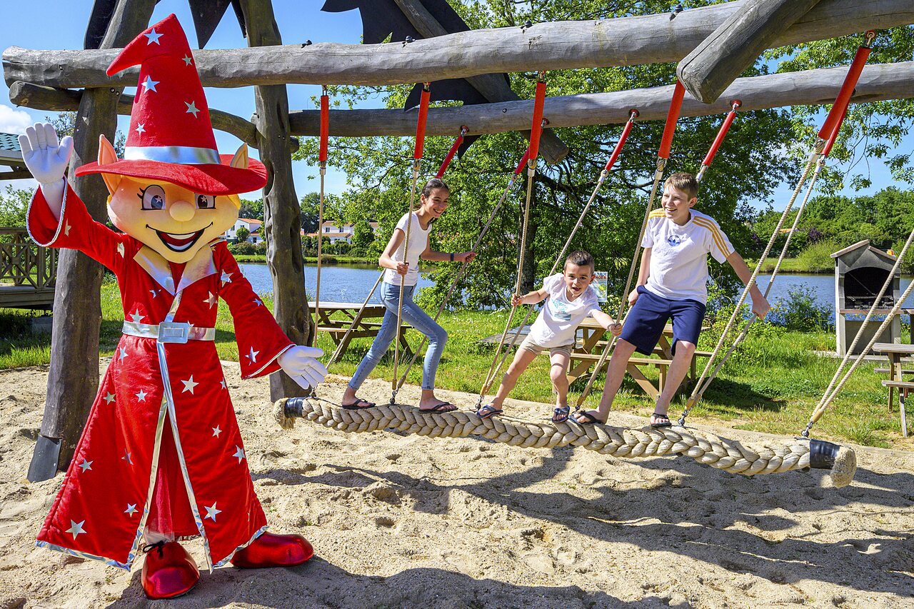 Mascotte et enfants jouant sur pont de cordes au camping CAPFUN Forges � Avrille (85).