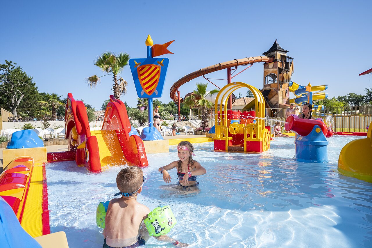 Aire de jeux aquatique avec toboggans et enfants au camping CAPFUN Forges � Avrille (85).