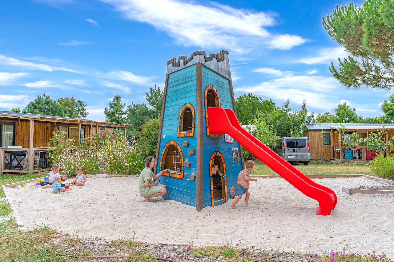 Aire de jeux avec tour en bois, toboggan et bac � sable au camping CAPFUN Forges � Avrille (85).