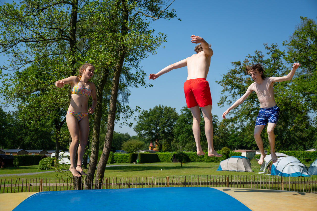 Adolescents sautant sur le coussin gonflable au camping CAPFUN Fort Bedmar � Sint-Gillis-Waas.