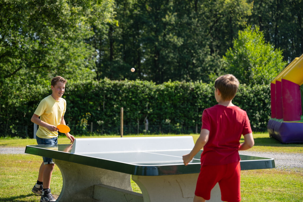 Deux gar�ons jouent au tennis de table ext�rieur au camping CAPFUN Fort Bedmar � Sint-Gillis-Waas.