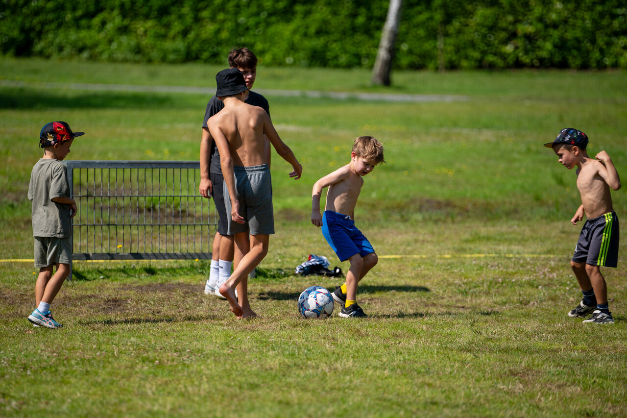 Enfants jouant au football sur un terrain de sport au camping CAPFUN Fort Bedmar � Sint-Gillis-Waas.