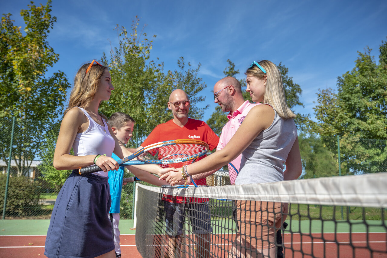 Famille et animateurs jouent au tennis au camping CAPFUN Fort Falabraque � Seltz.