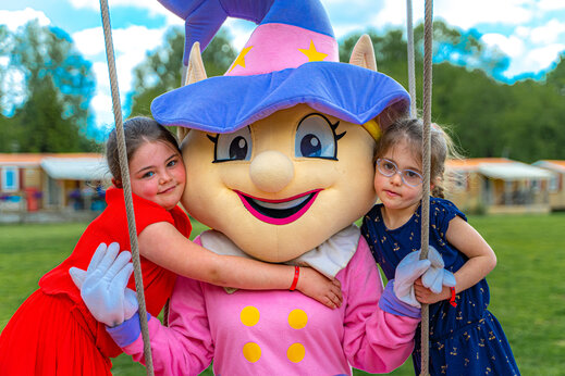 Deux filles étreignant une mascotte joyeuse au camping CAPFUN Fredland à Tournan en Brie (77).