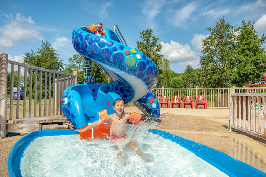 Toboggan aquatique ludique et enfants jouant dans la piscine au camping CAPFUN Fredland à Tournan en Brie (77).