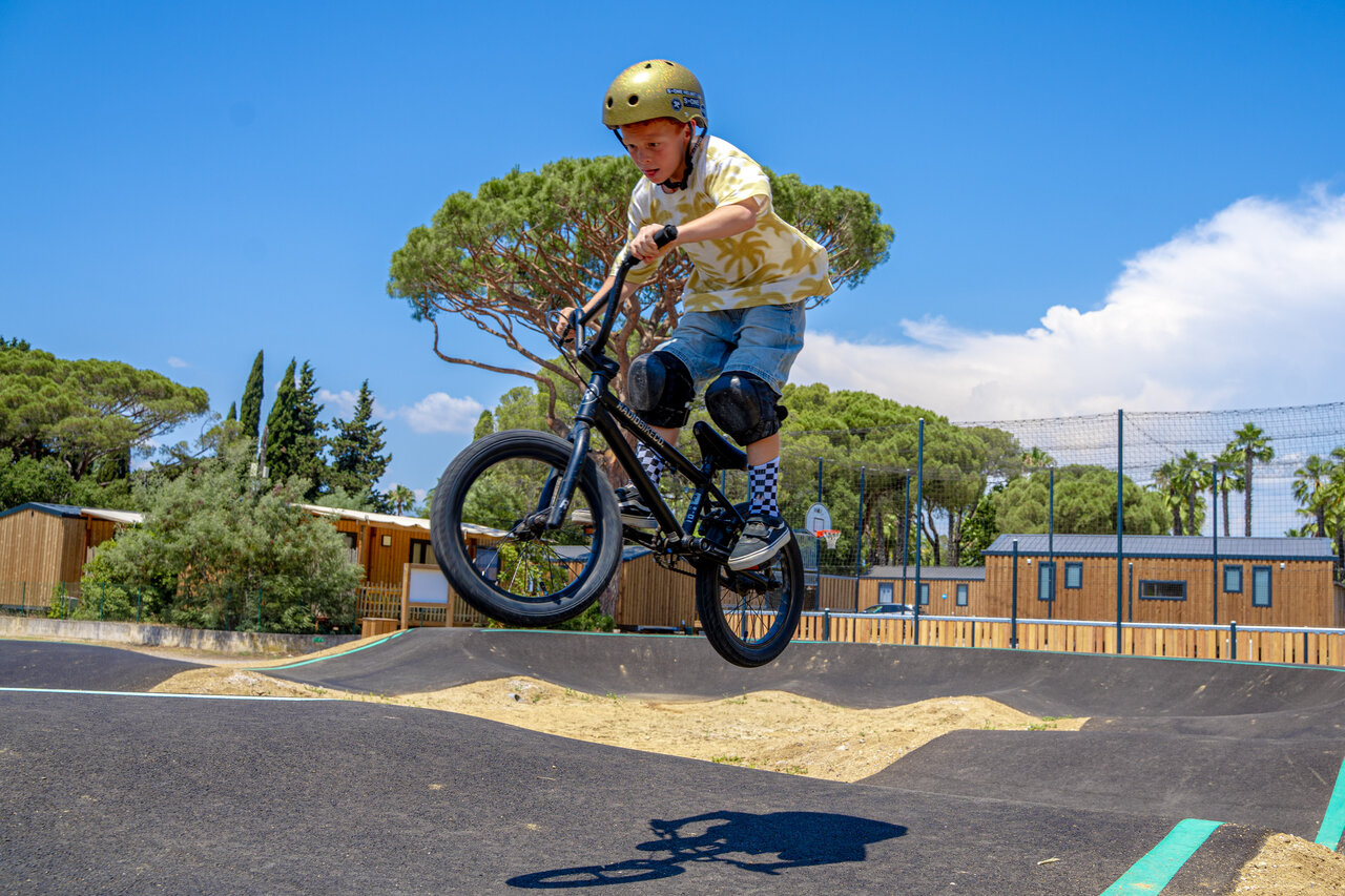 Enfant en BMX sautant sur le pump track au camping CAPFUN Le Fr�jus.