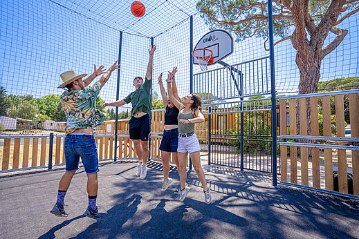 Jeunes jouant au basketball sur terrain multisport au camping CAPFUN Le Fr�jus (83).