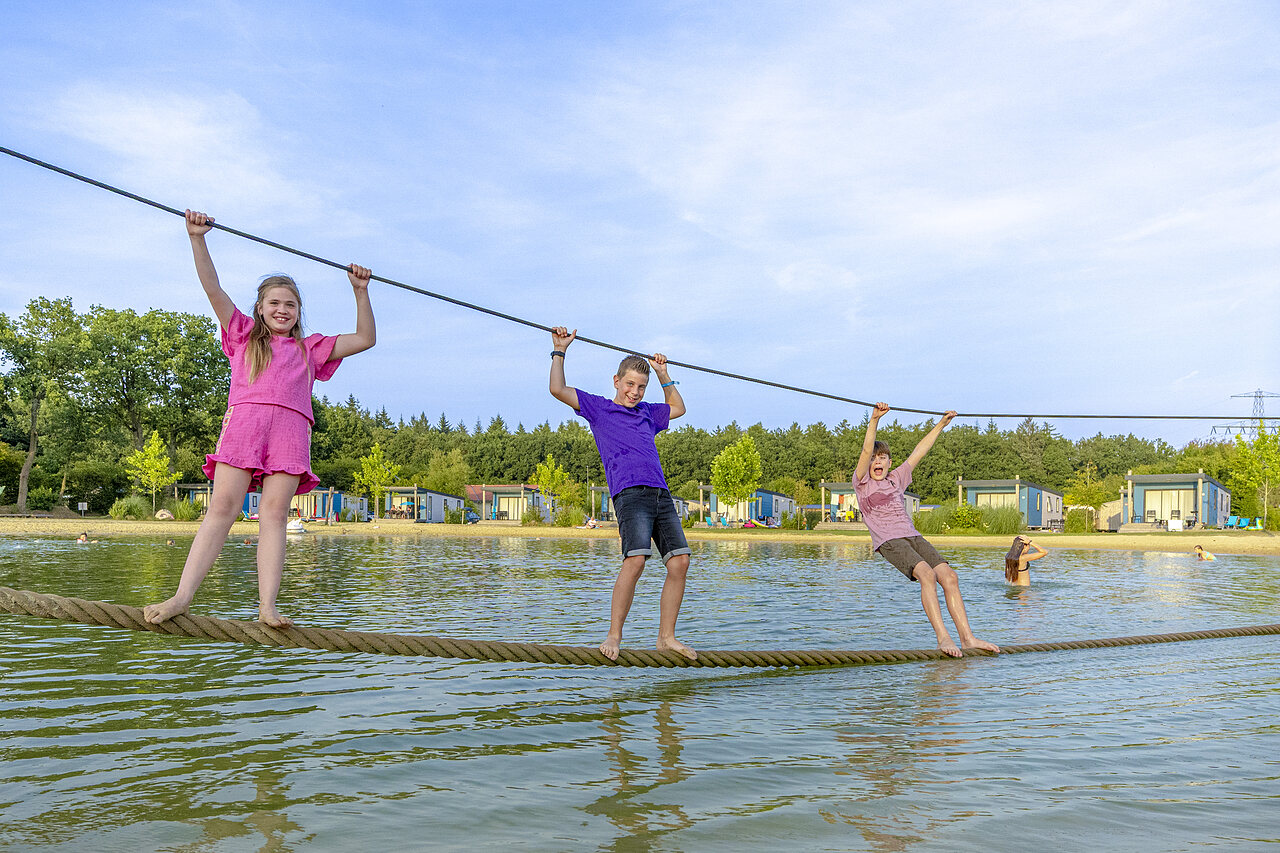 Enfants s'amusant sur un pont de cordes aquatique au camping CAPFUN De Fruithof � Klijndijk.