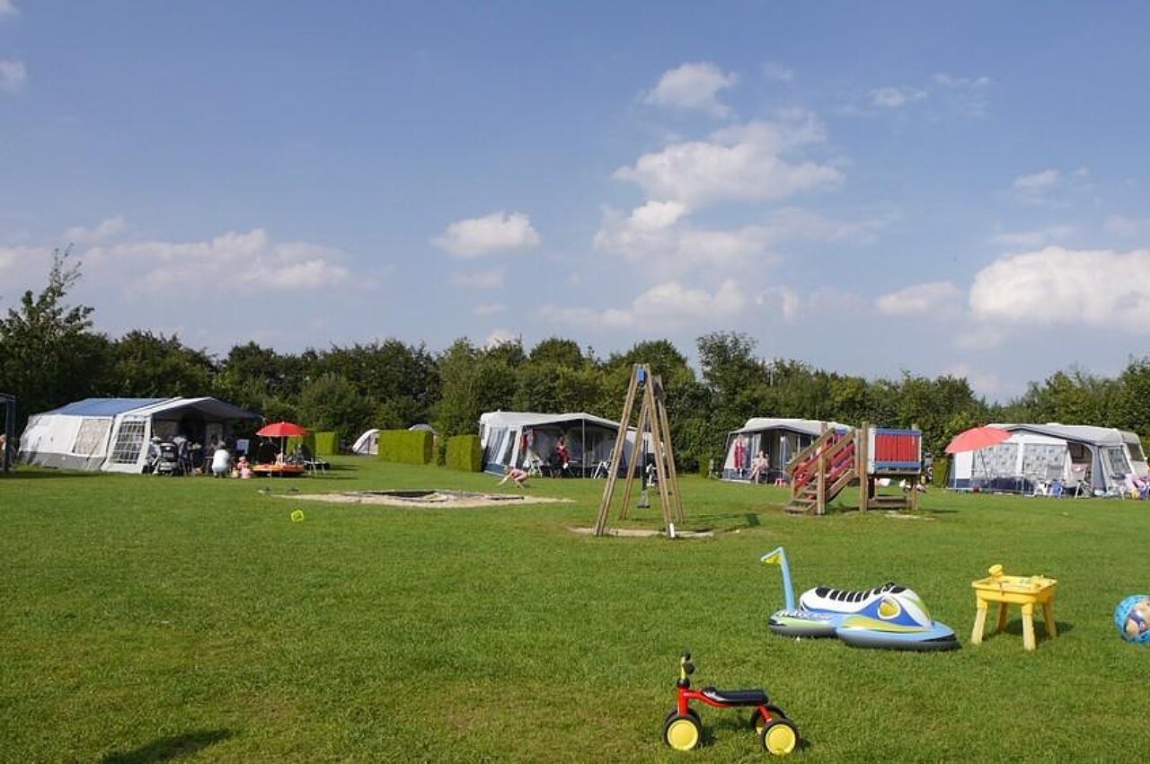 Emplacements de camping verdoyants avec aire de jeux pour enfants au camping CAPFUN De Fruithof � Klijndijk.