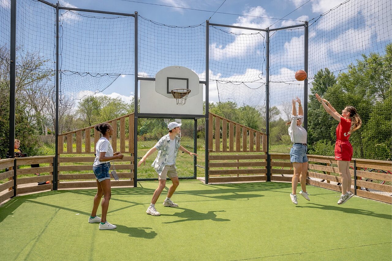 Terrain multisport avec jeunes jouant au basket au camping CAPFUN Golf � SAINT JEAN DE LA RIVIERE (50).