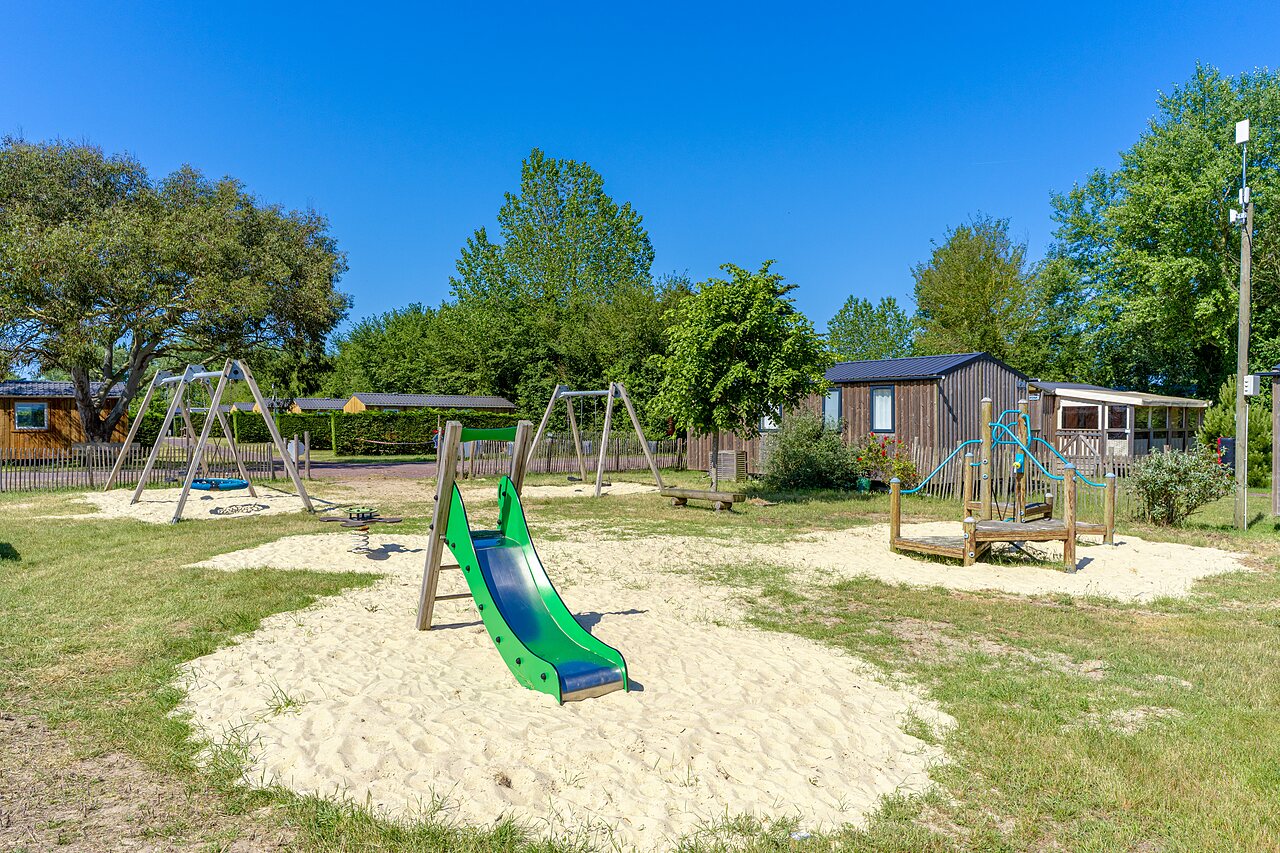 Aire de jeux avec toboggan et balan�oires au camping CAPFUN Golf, SAINT JEAN DE LA RIVIERE (50).