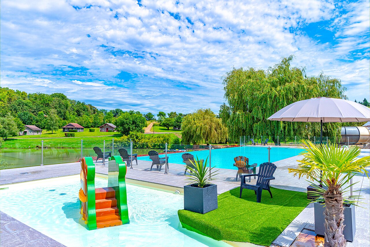 Piscine ext�rieure avec toboggan enfant et chaises longues au camping CAPFUN Grand Cerf � Gimouille (58).