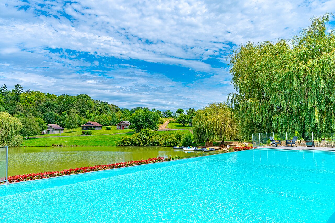 Piscine � d�bordement, lac et chalets au camping CAPFUN Grand Cerf � Gimouille (58).