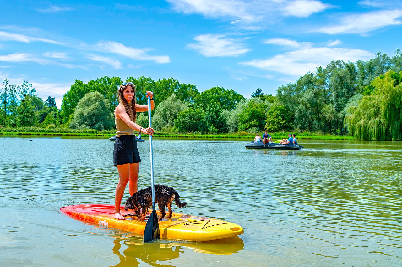 Femme et chien en stand-up paddle sur le lac au camping CAPFUN Grand Cerf � Gimouille (58).