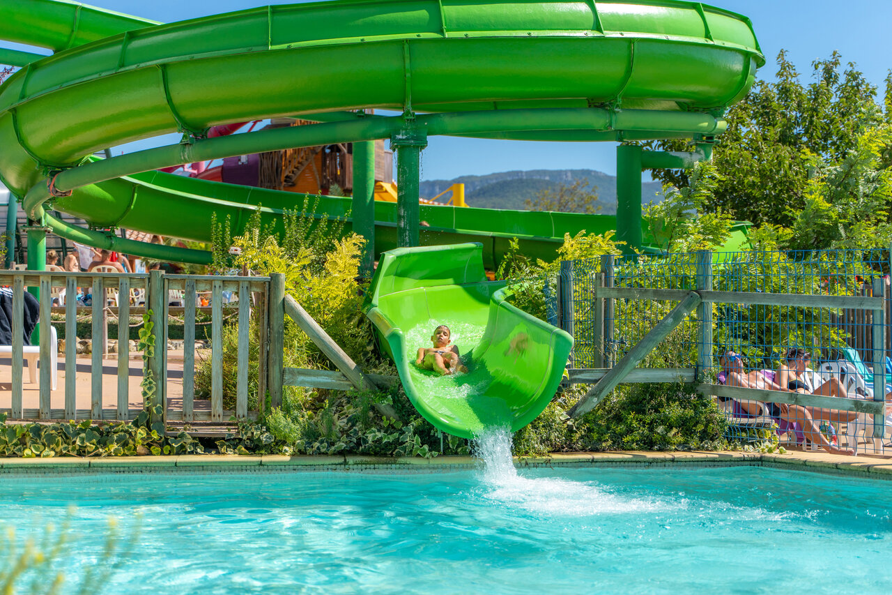Enfant sur toboggan aquatique vert g�ant et piscine au camping CAPFUN Grand Lierne � CHATEAUDOUBLE (26).