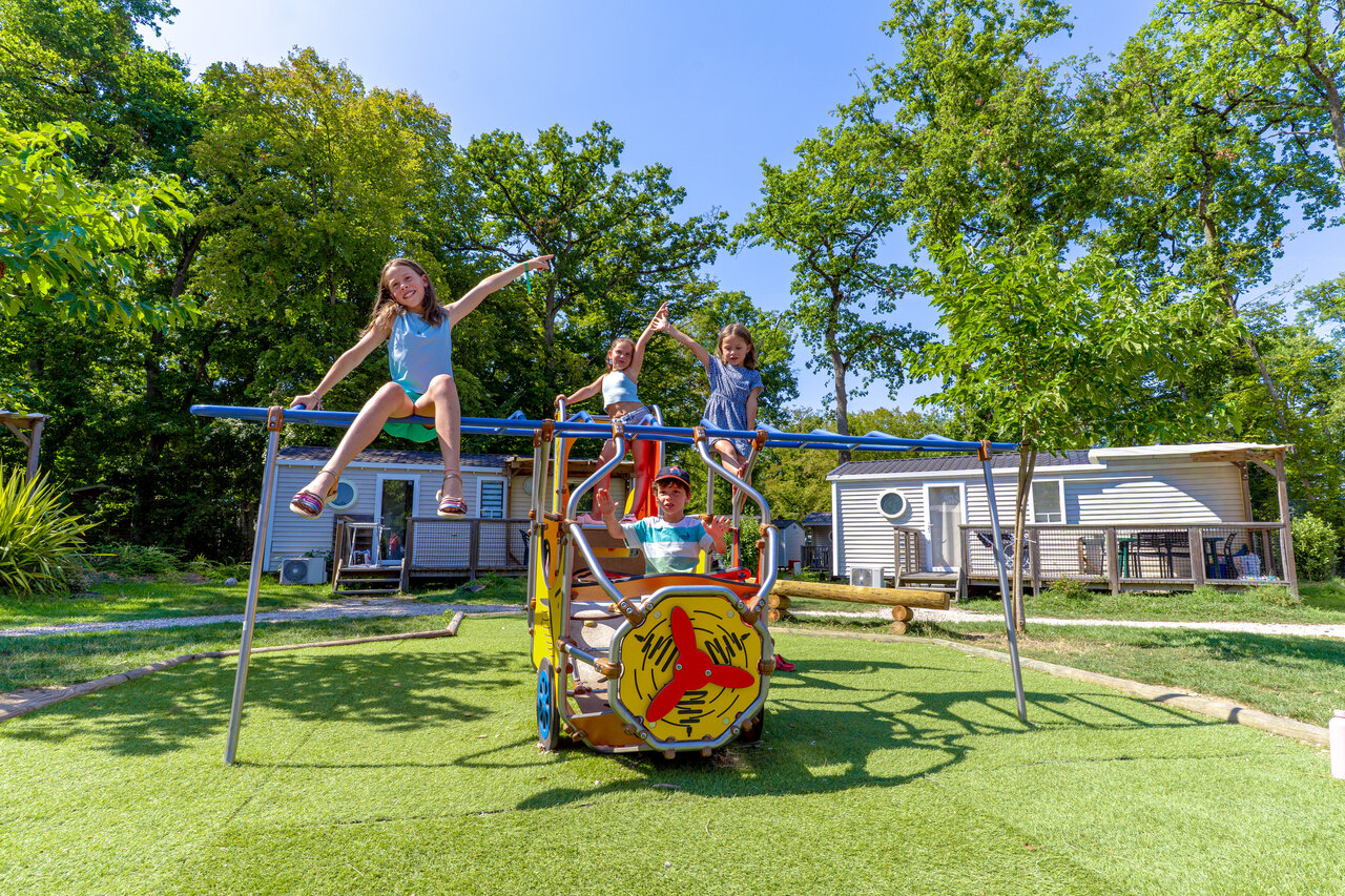 Enfants jouant sur l'aire de jeux avec mobile-homes au camping CAPFUN Grenouill�re � Su�vres (41).