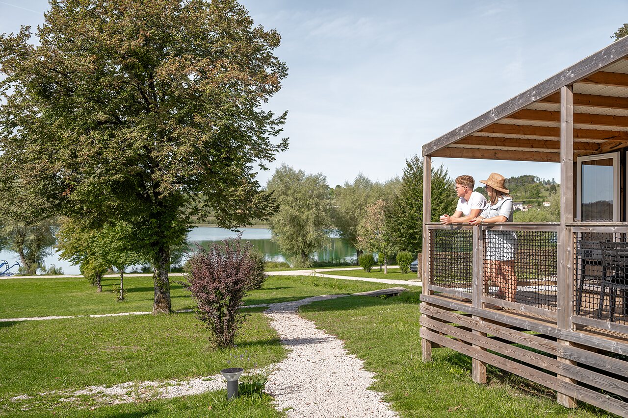 Couple sur terrasse mobile-home, vue lac au camping CLICOCHIC Grisi�re, Clairvaux-les-Lacs.