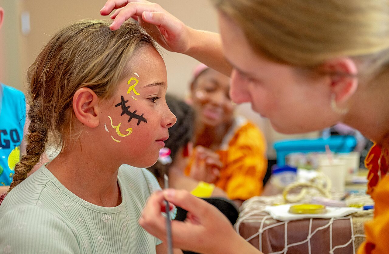 Enfant se faisant maquiller le visage lors d'une animation au camping VAGUES OCEANES Grosses Pierres � Saint-Georges-d'Ol�ron (17).