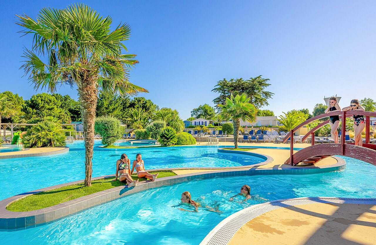 Piscine ext�rieure, rivi�re et palmiers au camping VAGUES OCEANES Grosses Pierres.