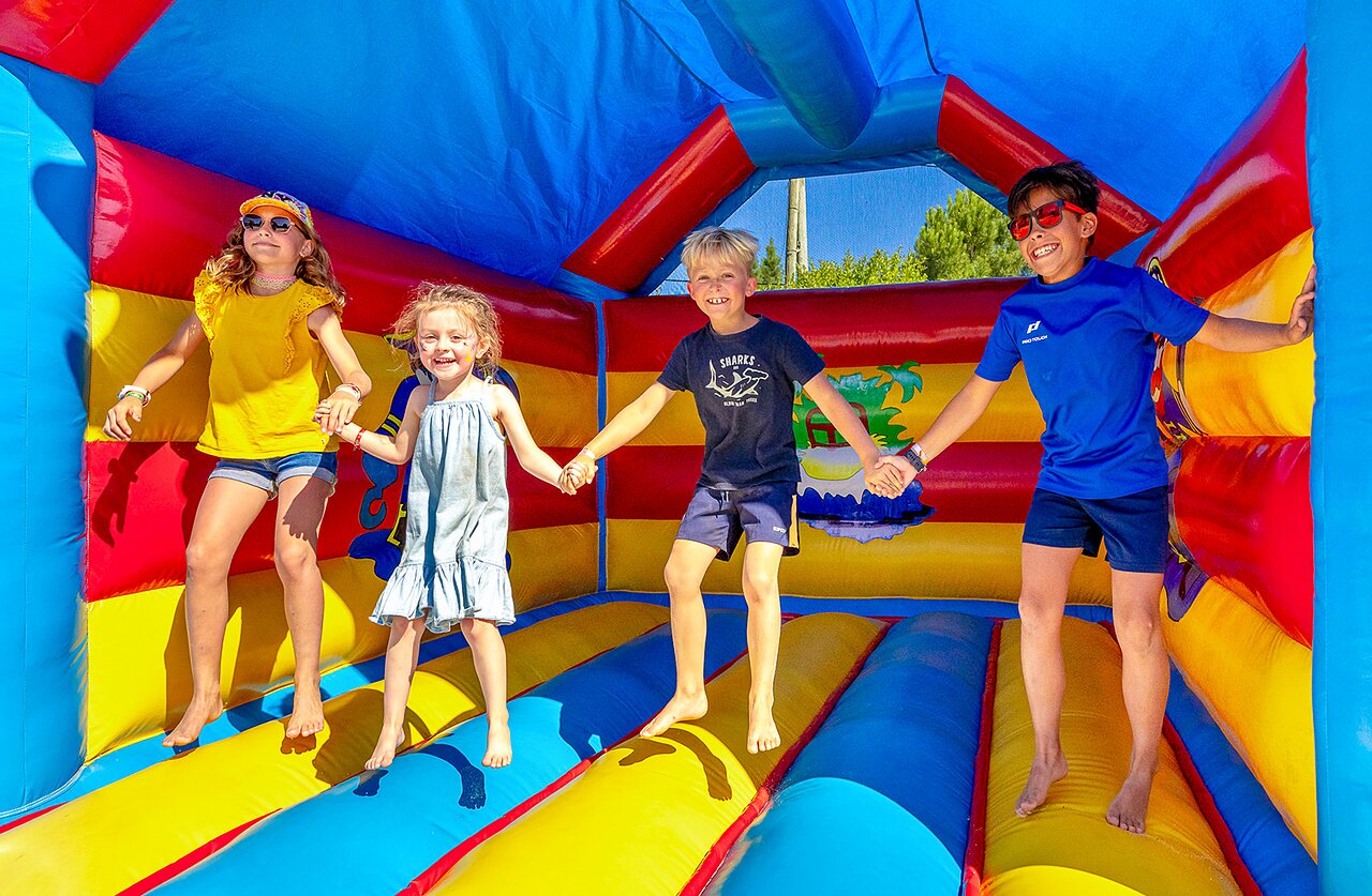 Enfants sautant dans ch�teau gonflable color�, camping VAGUES OCEANES Grosses Pierres.