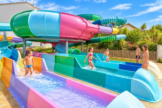 Toboggans aquatiques colorés et enfants s'amusant au camping VAGUES OCEANES Grosses Pierres à Saint-Georges-d'Oléron (17).