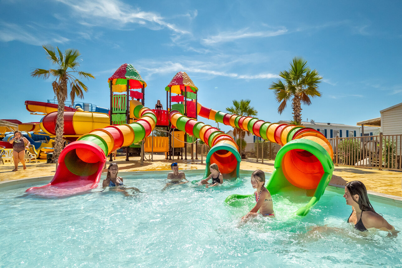 Piscine, toboggans aquatiques color�s et enfants au camping VAGUES OCEANES Hamacs � Fleury.