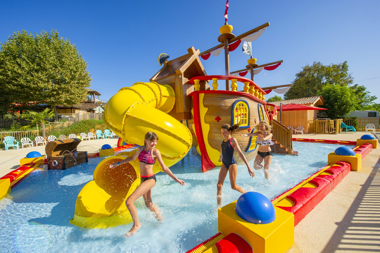Aire de jeux aquatique bateau pirate, toboggan jaune, enfants au camping CAPFUN Hauts de Ratebout � STE FOY DE BELVES (24).