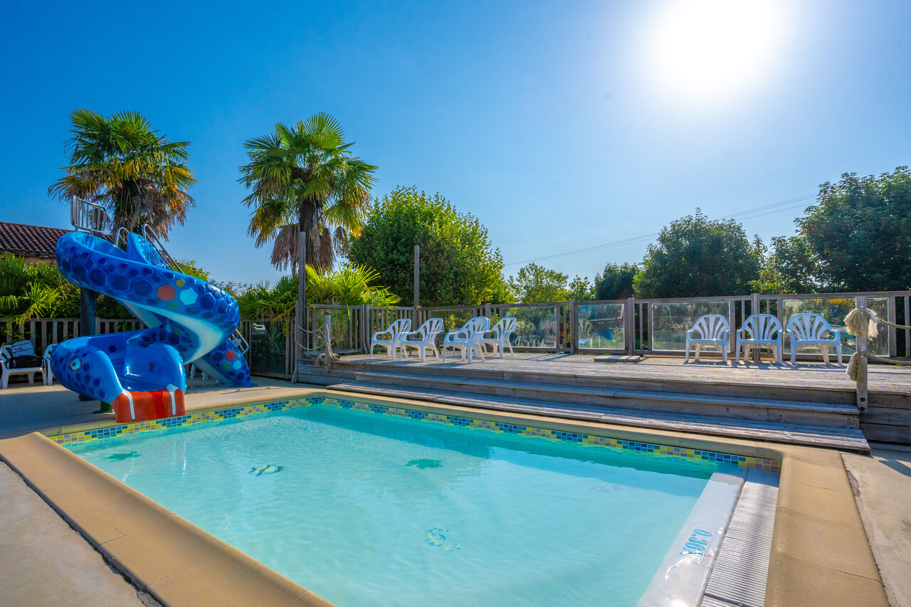 Piscine et toboggan aquatique bleu au camping CAPFUN Hauts de Ratebout � STE FOY DE BELVES (24).