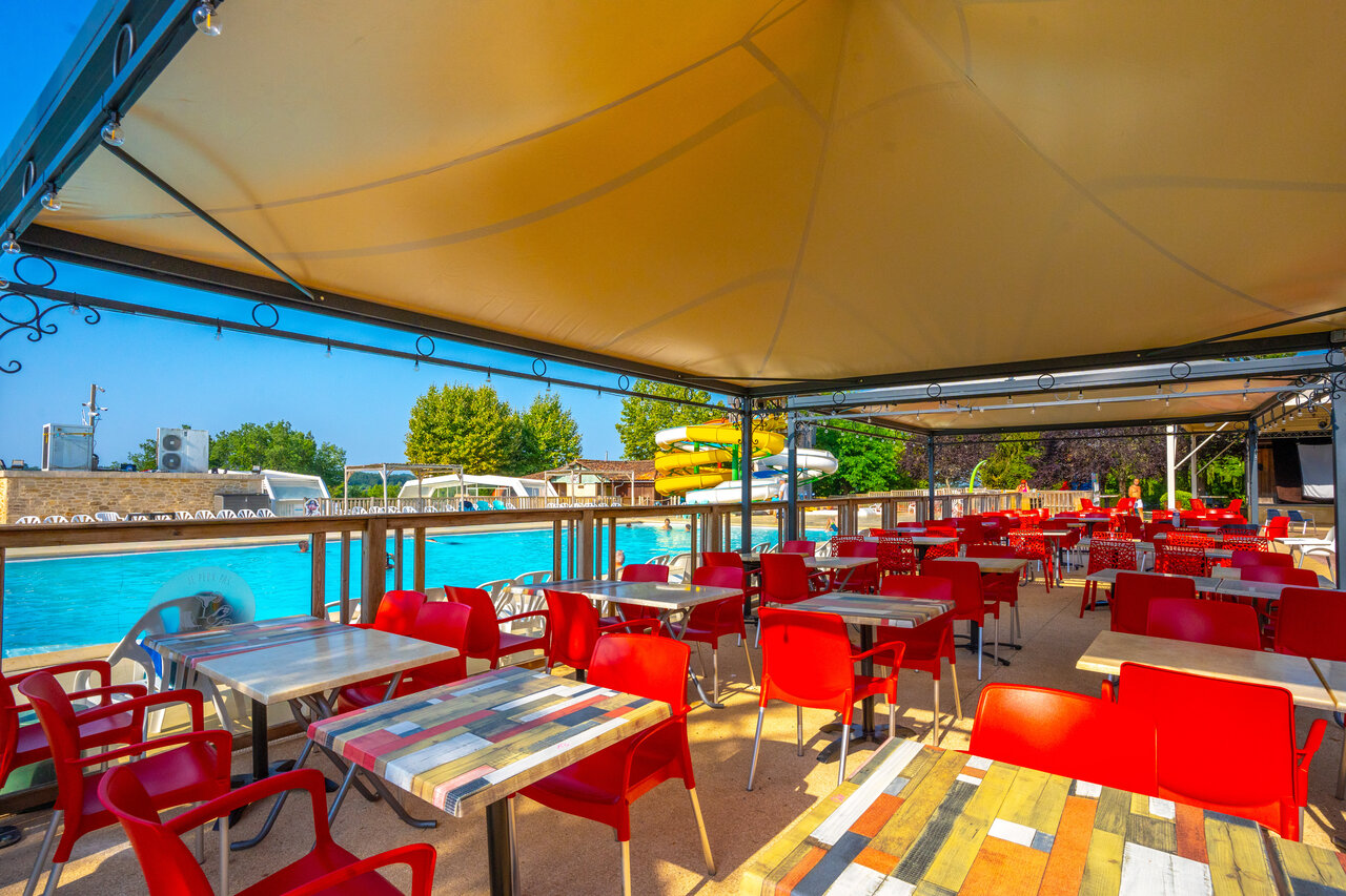 Restaurant ext�rieur, piscine et toboggans au camping CAPFUN Hauts de Ratebout (24).