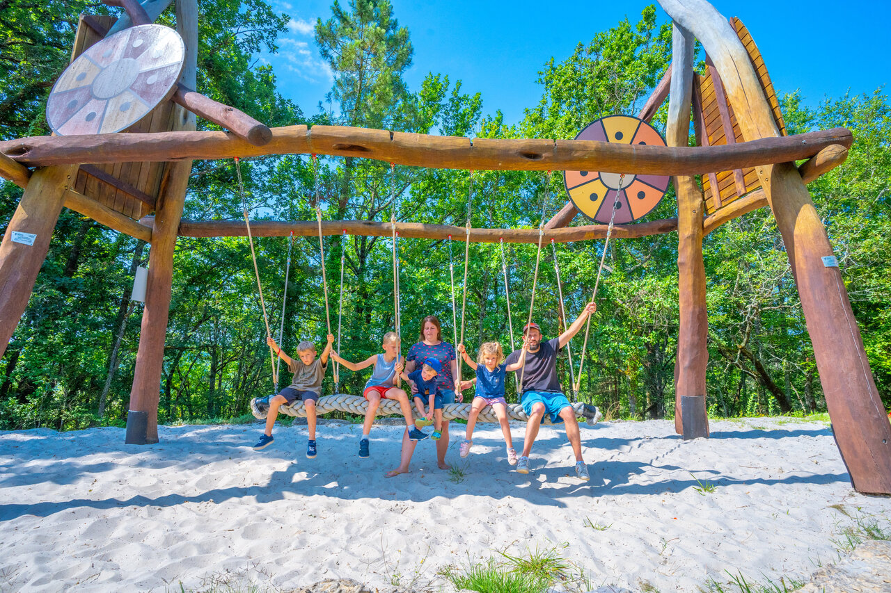 Famille profitant d'une balan�oire g�ante sur sable au camping CAPFUN Hauts de Ratebout � STE FOY DE BELVES (24).