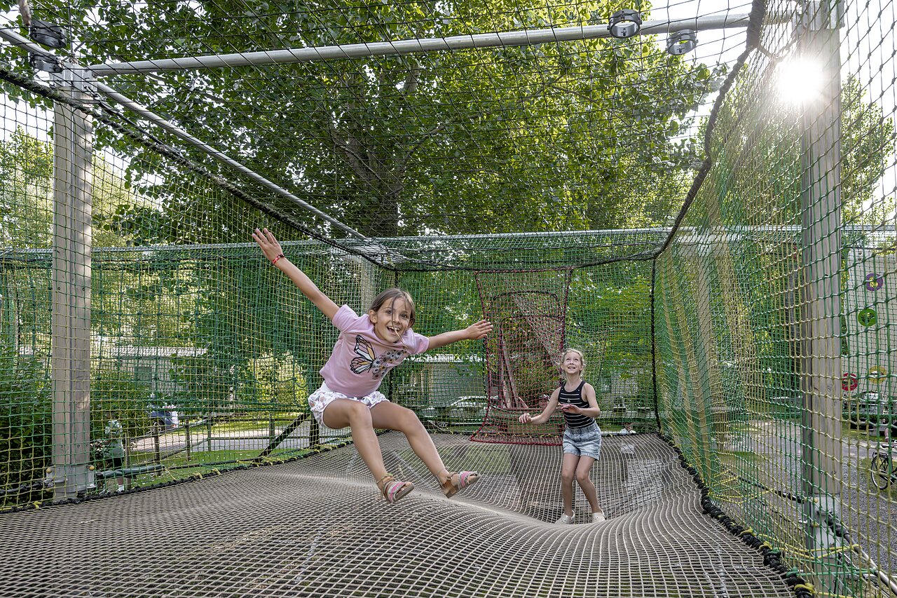 Enfants s'amusant sur un trampoline g�ant en filet au camping CLICOCHIC Havre de Berni�res.