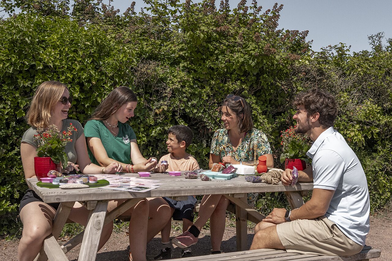 Famille participant � un atelier cr�atif en plein air au camping CLICOCHIC Havre de Berni�res.