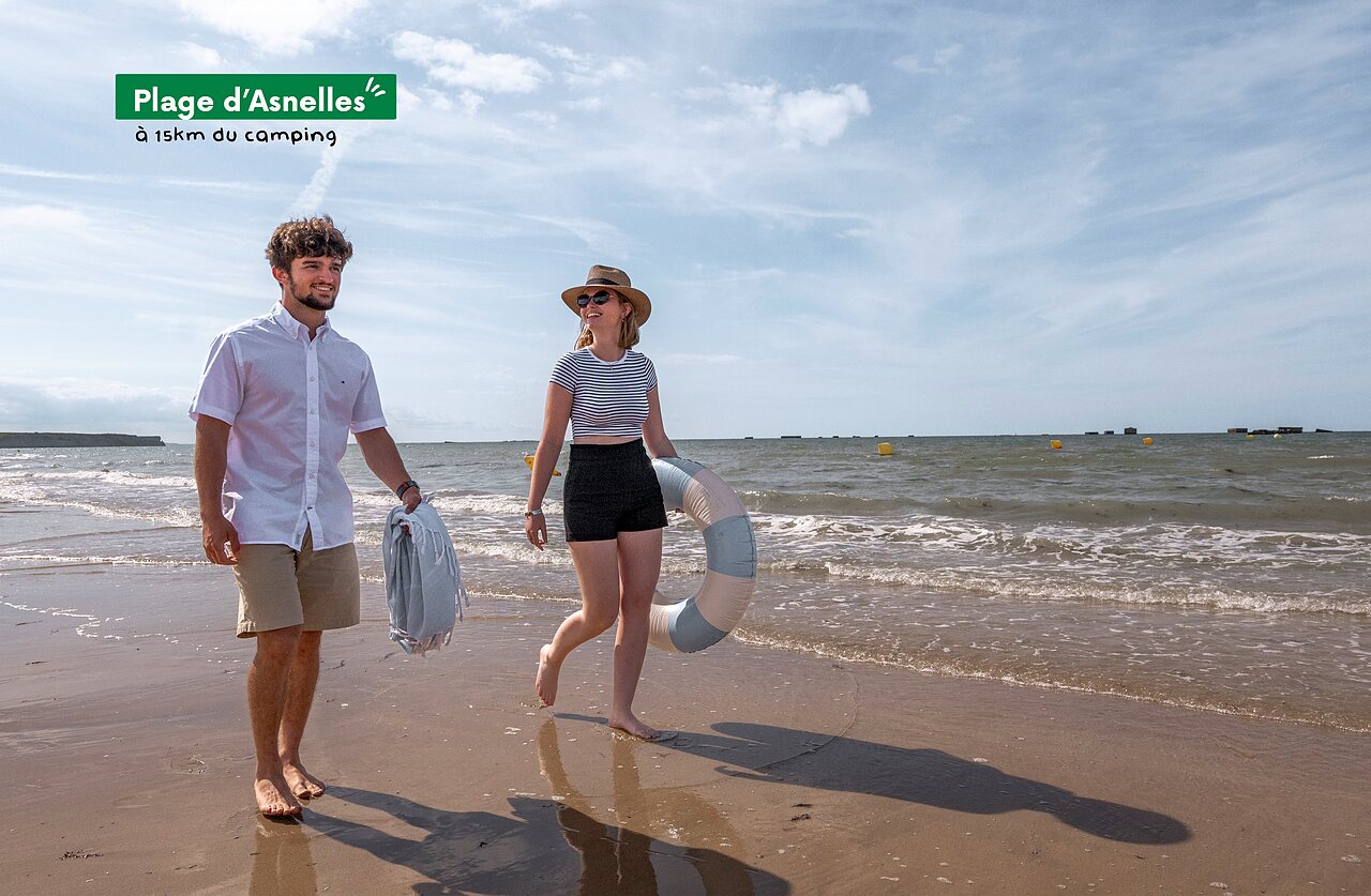 Plage d'Asnelles, couple se promenant au bord de l'eau, Normandie.