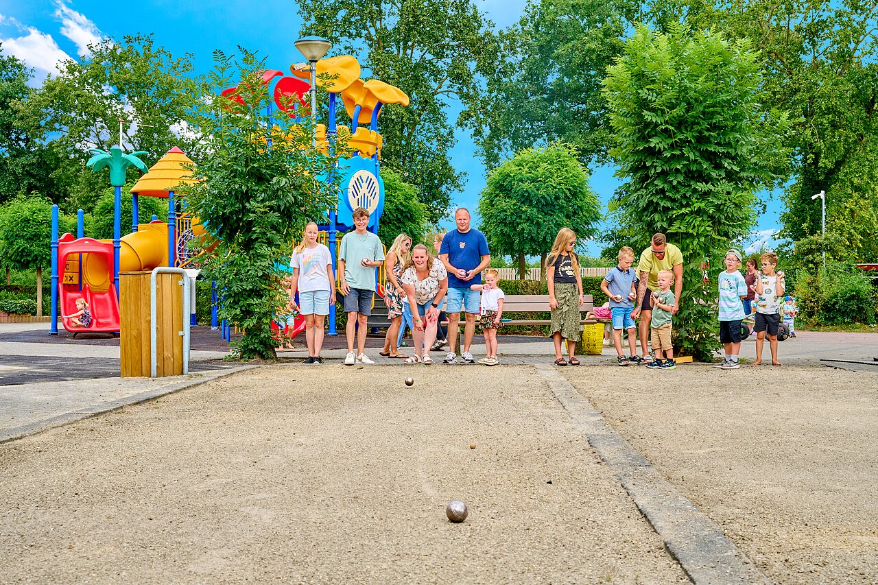 Famille jouant � la p�tanque pr�s d'une aire de jeux au camping CAPFUN Heino � Heino.