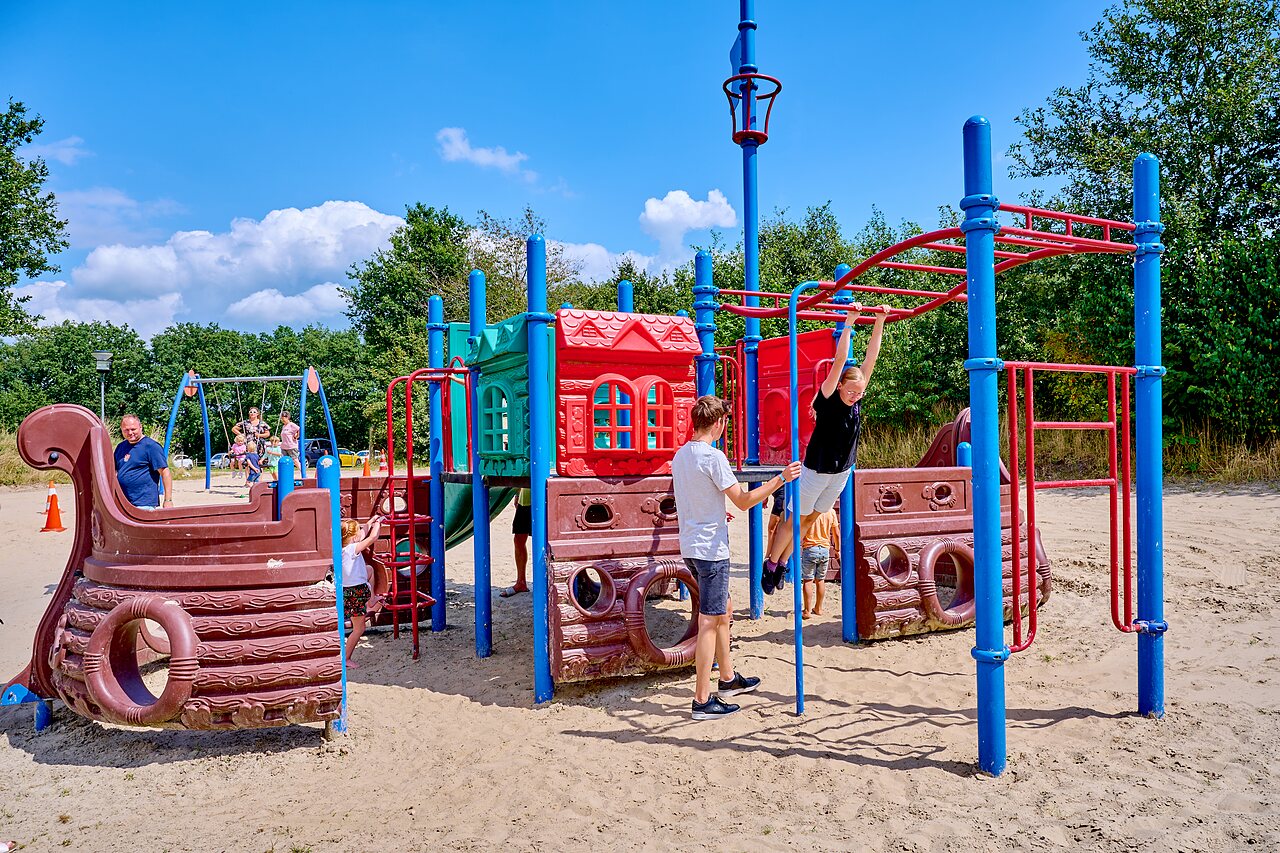 Aire de jeux color�e avec structures, toboggans et balan�oires au camping CAPFUN Heino.