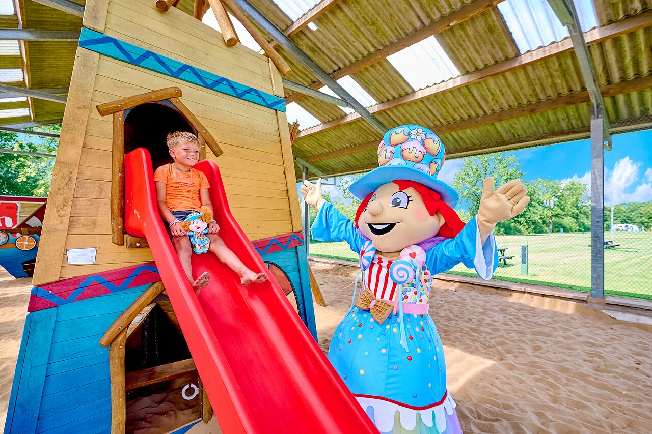 Enfant sur toboggan et mascotte au parc de jeux, camping CAPFUN Heino � Heino.