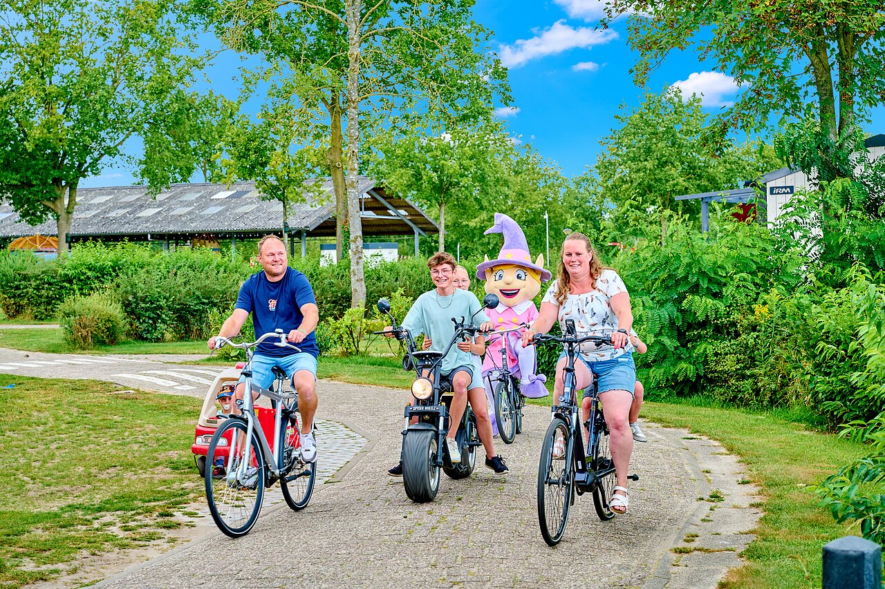 Famille et mascotte � v�lo sur une all�e au camping CAPFUN Heino � Heino.