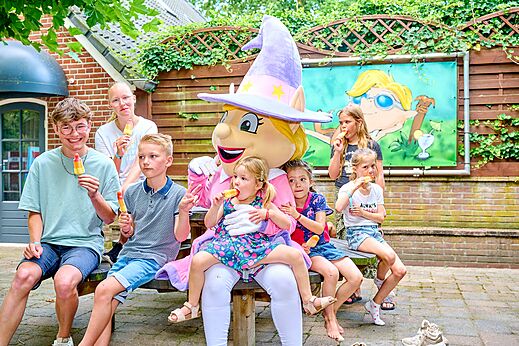 Mascotte et enfants souriants mangeant des glaces au camping CAPFUN Heino à Heino.