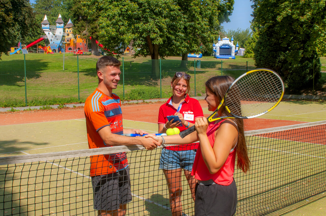 Joueurs de tennis et animateur sur le court au camping CAPFUN Hirondelle � Oteppe.