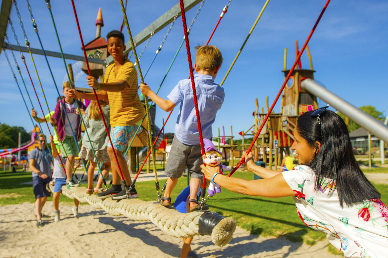 Aire de jeux avec pont de cordes et enfants au camping CAPFUN Hirondelle � Oteppe.