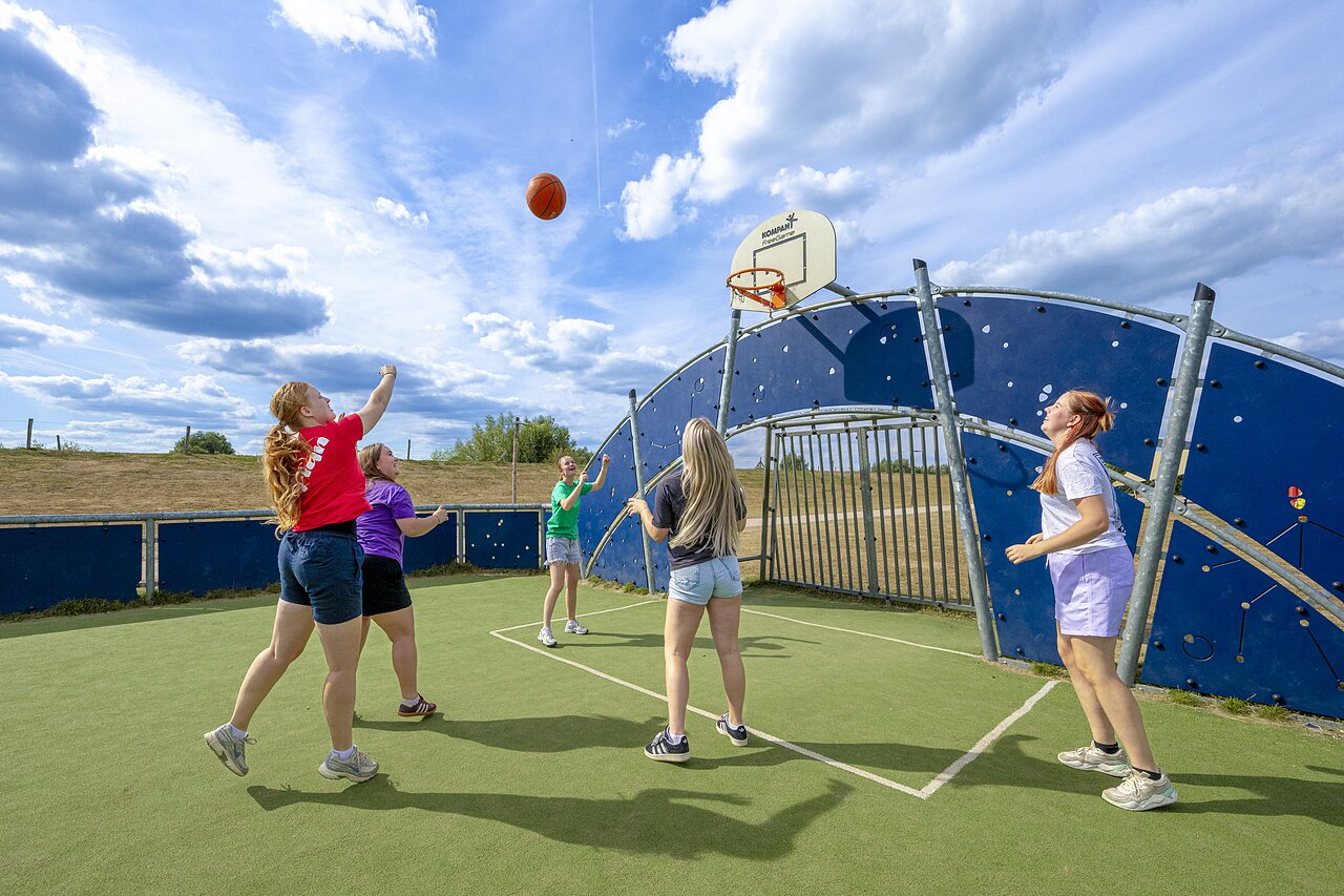 Jeunes jouant au basketball sur un terrain multisport au camping CAPFUN IJsselstrand � Doesburg.