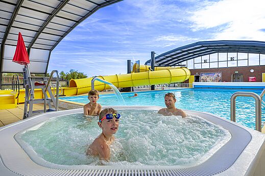 Jacuzzi bouillonnant, piscine et toboggan jaune au camping CAPFUN IJsselstrand à Doesburg.